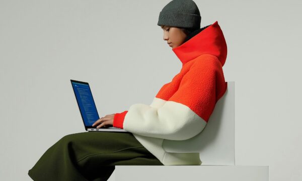 Person in Color-Blocked Jacket with Laptop Person in Color-Blocked Jacket with Laptop